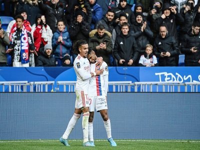 La recrue lyonnaise Tetê félicitée par Malo Gusto après son premier but en Ligue 1 contre Angers à Décines, le 3 avril 2022 - OLIVIER CHASSIGNOLE [AFP]