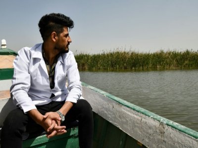 Le vétérinaire irakien Karrar Ibrahim Hindi assis dans une barque à moteur, le 26 mars 2022 - Asaad NIAZI [AFP]