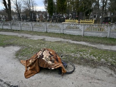 Le corps d'un cycliste tué, recouvert d'une couverture, à Makariv (Ukraine) le 4 avril 2022 - Sergei SUPINSKY [AFP]