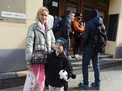 La réfugiée ukrainienne Katerina et son fils Ilia font la queue devant un cinéma où l'on distribue des vêtements et des jouets, le 11 avril 2022 à Lviv - Yuriy Dyachyshyn [AFP]