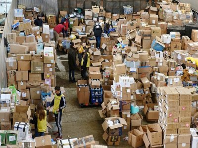 Des bénévoles dans un entrepôt où sont stockés des vêtements et de la nourriture pour les déplacés ukrainiens, le 11 avril 2022 à Lviv - Yuriy Dyachyshyn [AFP]