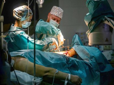 Des chirurgiens opèrent un soldat ukrainien blessé à la jambe, dans un hôpital militaire ukrainien à Zaporojie, le 18 avril 2022 - Ed JONES [AFP]