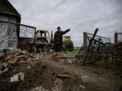 Vassili Kouchtch devant le cratère laissé par une roquette dans le village de Mala Tokmachka, le 23 avril 2022 en Ukraine - Ed JONES [AFP]