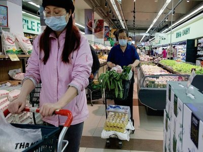 Des personnes achètent de la nourriture et des produits ménagers dans un supermarché de Pékin, le 25 avril 2022 - Noel Celis [AFP]