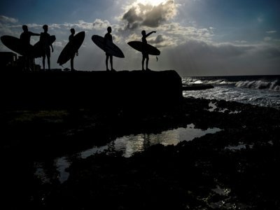Des surfeurs cubains sur la côte de La Havane, le 4 avril 2022 - YAMIL LAGE [AFP]