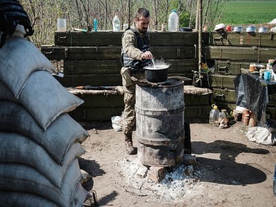 Un soldat ukrainien prépare un repas à Barvinkove, dans l'est du pays, le 25 avril 2022 - Yasuyoshi CHIBA [AFP]