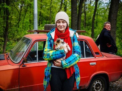 Svitlana Pereshelitca, 23 ans, et son chien Bairaktar, quui ont fuit le village de Ruska Lozova, prennent la pose après leur évacuation à Kharkiv, est de l'Ukraine, le 29 avril 2022 - Dimitar DILKOFF [AFP]