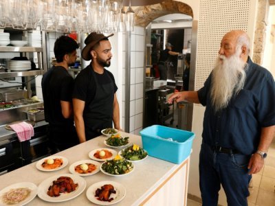 Le cuisinier israélien Uri Jeremias discutant avec des employés dans son restaurant de fruits de mer à Acre, le 2 mai 2022 - JACK GUEZ [AFP]