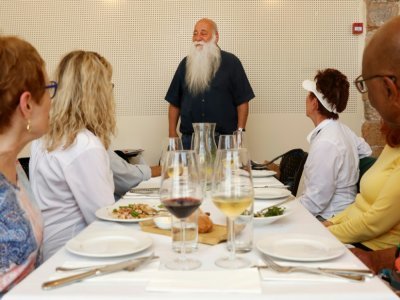 Le chef israélien Uri Jeremias accueillant des touristes américains dans son restaurant de fruits de mer à Acre, dans le nord d'Israël, le 2 mai 2022 - JACK GUEZ [AFP]