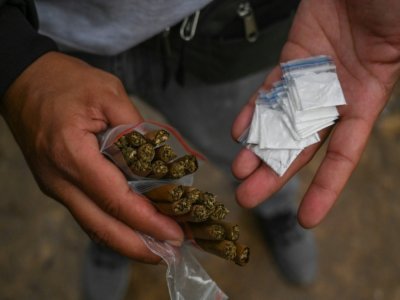 Un dealer montre les joints de marijuana et les paquets de cocaïne qu'il vend dans un parc du centre de Medellin, le 23 mars 2022 - JOAQUIN SARMIENTO [AFP/Archives]