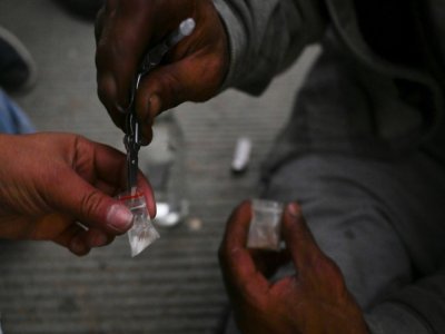 Un toxicomane se prépare une dose de speedball, mélange de cocaïne et d'héroïne, dans le centre de Medellin, en Colombie, le 1er mars 2022 - JOAQUIN SARMIENTO [AFP/Archives]