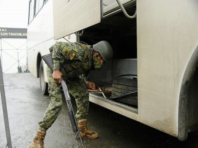 Un soldat inspecte un bus devant la prison de Bellavista, dans la province de Santo Domingo de los Tsachilas (Equateur), le 10 mai 2022 - Rodrigo BUENDIA [AFP]