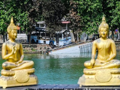 Un bus incendié et en partie plongé dans un lac à la suite des manifestations antigouvernementales à Colombo, capitale du Sri Lanka, le 11 mai 2022 - ISHARA S. KODIKARA [AFP]