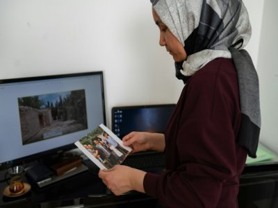 La Ouïghoure Nursimangul Abdureshid regarde une photo de sa famille restée en Chine, lors d'une interview avec l'AFP, le 12 mai 2022 à Istanbul, en Turquie - Yasin AKGUL [AFP]