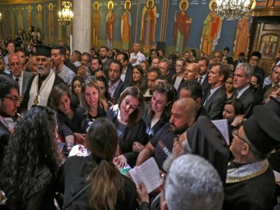 Des Palestiniens prient autour du cercueil de la journaliste Shireen Abou Akleh dans une église à Jérusalem, le 13 mai 2022 - RONALDO SCHEMIDT [AFP]