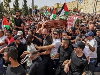 Des hommes palestiniens portent le cercueil de la journaliste Shireen Abu Akleh lors d'une procession à Jérusalem, le 13 mai 2022 - RONALDO SCHEMIDT [AFP]