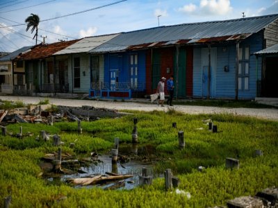 Deux hommes marchent dans le village de Isabela de Sagua, à Cuba le 27 avril 2022 - YAMIL LAGE [AFP]