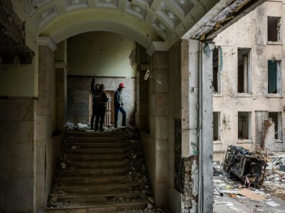 Des ingénieurs examinent un bâtiment endommagé à Kharkiv, le 16 mai 2022 - Dimitar DILKOFF [AFP]