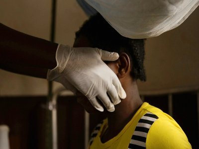 Un médecin examine une femme infectée par la variole du singe dans une zone de quarantaine du centre de Médecins sans Frontières, en octobre 2018 à Zomea Kala, en Centrafrique - CHARLES BOUESSEL [AFP/Archives]