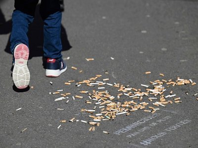 Des mégots de cigarettes qui jonchent un trottoir, à Paris, le 14 mars 2022 - Emmanuel DUNAND [AFP]