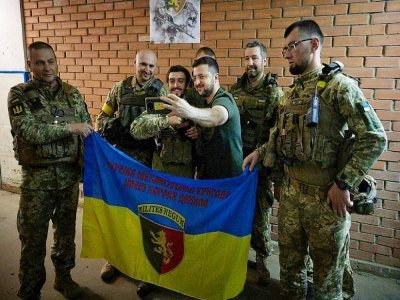 Le président ukrainien Volodymyr Zelensky fait un selfie avec des soldats lors de sa visite sur la ligne de front, dans l'est de l'Ukraine, selon cette photo diffusée le 6 juin 2022 par la présidence - STR [UKRAINIAN PRESIDENTIAL PRESS SERVICE/AFP]