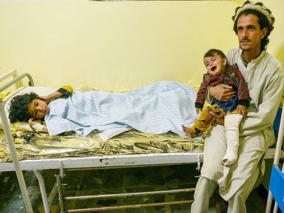 Un Afghan tient un enfant soigné dans un hôpital de la ville de Sharan après avoir été blessé dans le séisme qui a frappé le sud-est de l'Afghanistan, le 22 juin 2022 - Ahmad SAHEL ARMAN [AFP]