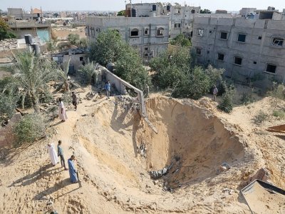 Des habitants autour d'un cratère après trois jours d'hostilités entre Israël et le Jihad islamique, le 8 août 2022 à Rafah, dans le sud de la bande de Gaza - SAID KHATIB [AFP]