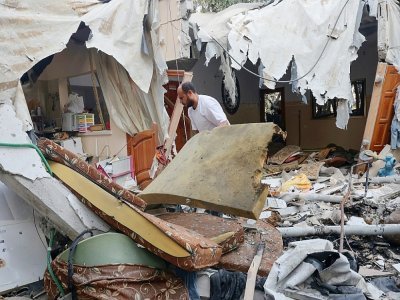 Un Palestinien récupère des affaires dans les décombres de sa maison, le 8 août 2022 à Rafah, dans le sud de la bande de Gaza - SAID KHATIB [AFP]