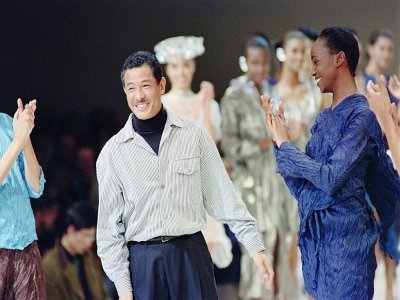 Le créateur de mode japonais Issey Miyake applaudi par ses mannequins , le 19 octobre 1991 à Paris, après la présentation de sa collection Printemps-Eté 92 - Pierre GUILLAUD [AFP/Archives]