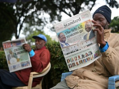 Des hommes lisent le journal pour s'informer des résultats de l'élection présidentielle au Kenya, le 13 août 2022 à Eldoret - Simon MAINA [AFP]
