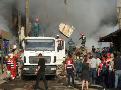 Des équipes de secours sur le site d'une explosion d'origine indéterminée qui a fait au moins six morts dans une zone commerciale d'Erevan, le 14 août 2022 en Arménie - Karen MINASYAN [AFP]