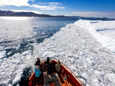 Des touristes à bord d'un bateau dans la baie de Disko, le 28 juin 2022 à Ilulissat, au Groenland - Odd ANDERSEN [AFP/Archives]