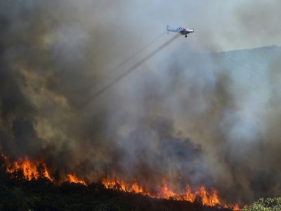 Un avion bombardier d'eau survole un incendie près de Gignac, dans le sud de la France, le 26 juillet 2022 - Sylvain THOMAS [AFP/Archives]