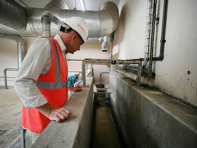 Un homme observe le processus de prétraitement des eaux usées, à la station d'épuration de Narbonne, dans le sud de la France, le 18 août 2022 - Valentine CHAPUIS [AFP]