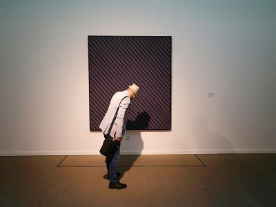 Un homme contemple une oeuvre de l'artiste américain Frank Stella à Téhéran, le 22 août 2022 - ATTA KENARE [AFP]