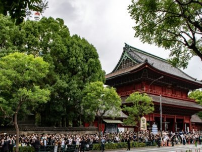 Des personnes se pressent prè du temple bouddhiste Zozoji où doivent se tenir les obsèques privées de l'ex-Premier ministre japonais assassiné Shinzo Abe à Tokyo, le 12 juillet 2022 - Philip FONG [AFP/Archives]