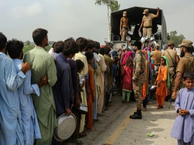 Des militaires procèdent à une distribution de nourriture pour des sinistrés après de violentes pluies de mousson, le 27 août 2022 à Rajanpur (Pakistan) - Shahid Saeed MIRZA [AFP]