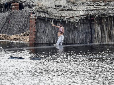 Un habitant traverse à gué une zone inondée après de fortes pluies de mousson dans la banlieue de Sukkur, dans la province du Sindh, le 27 août 2022 - Asif HASSAN [AFP]
