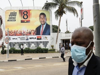 Un homme passe devant une affiche de campagne au siège du Mouvement populaire pour la libération de l'Angola (MPLA), deux jours après les élections générales, à Luanda, le 26 août 2022 - JOHN WESSELS [AFP/Archives]