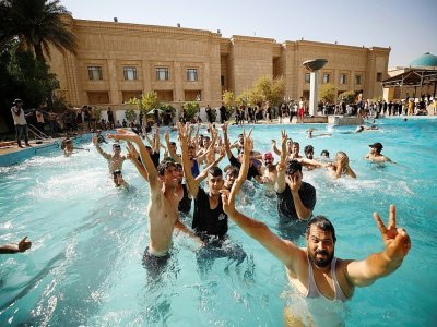 Des partisans de Moqtada Sadr se baignant dans un bassin dans la cour arrière du palais de la République à Bagdad, le 29 août 2022 - Ahmad Al-rubaye [AFP]