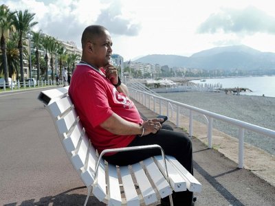 Bruno Razafitrimo assis sur un banc sur la promenade des Anglais à Nice le 1er juillet 2022 a perdu sa femme lors de l'attentat du 14 juillet 2016 - Valery HACHE [AFP/Archives]