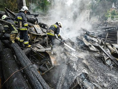 Les pompiers éteignent les décombres en feu d'un restaurant détruit par un missile à Kharkiv, dans l'est de l'Ukraine, le 4 septembre 2022 - SERGEY BOBOK [AFP]