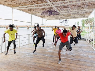 Des danseurs du Don Sen Folo Lab, une association culturelle malienne de création artistique, s'entraînent avant l'inauguration du premier bateau de résidence d'artistes du Mali sur le fleuve Niger, à Bamako, le 31 août 2022 - OUSMANE MAKAVELI [AFP]