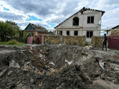 Un cratère devant une maison endommagée de la localité ukrainienne de Siversk, dans la région de Donetsk, prise entre les tirs des forces de Kiev et celles de Moscou, le 7 septembre 2022. - Juan BARRETO [AFP]