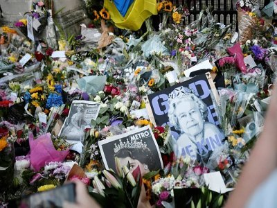 Bouquets de fleurs, photos et messages ont été déposés par des anonymes devant le palais de Buckingham depuis le décès d'Elizabeth II - STEPHANE DE SAKUTIN [AFP]