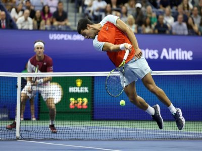 Carlos Alcaraz (d) renvoie la balle face à Casper Ruud en finale de l'US Open, à New York, le 11 septembre 2022 - AL BELLO [GETTY IMAGES NORTH AMERICA/AFP]