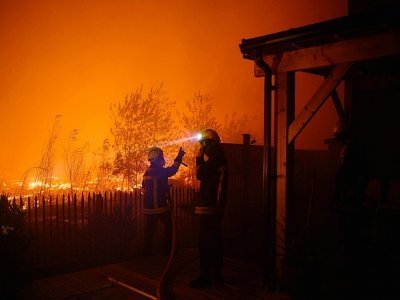 Des pompiers tentent de protéger des maisons d'un incendie de forêt à Saumos, le 12 septembre 2022 en Gironde, dans le sud-ouest de la France - PHILIPPE LOPEZ [AFP]