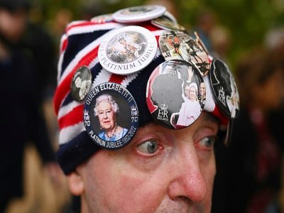 Le royaliste John Loughery, portant des images de la reine Elizabeth II sur son bonnet, près de Buckingham Palace à Londres le 13 septembre 2022 - Marco BERTORELLO [AFP]