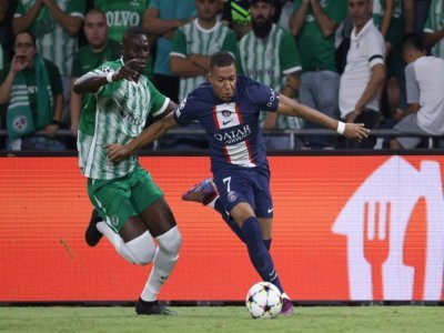 Kylian Mbappé (d) déborde un adversaire sur le terrain du Maccabi Haïfa, le 14 septembre 2022 - RONALDO SCHEMIDT [AFP]