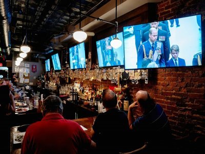 Des clients du pub "Queen Vic" suivent les funérailles de la reine Elizabeth II à la télévision, le 19 septembre 2022 à Washington - Stefani Reynolds [AFP]